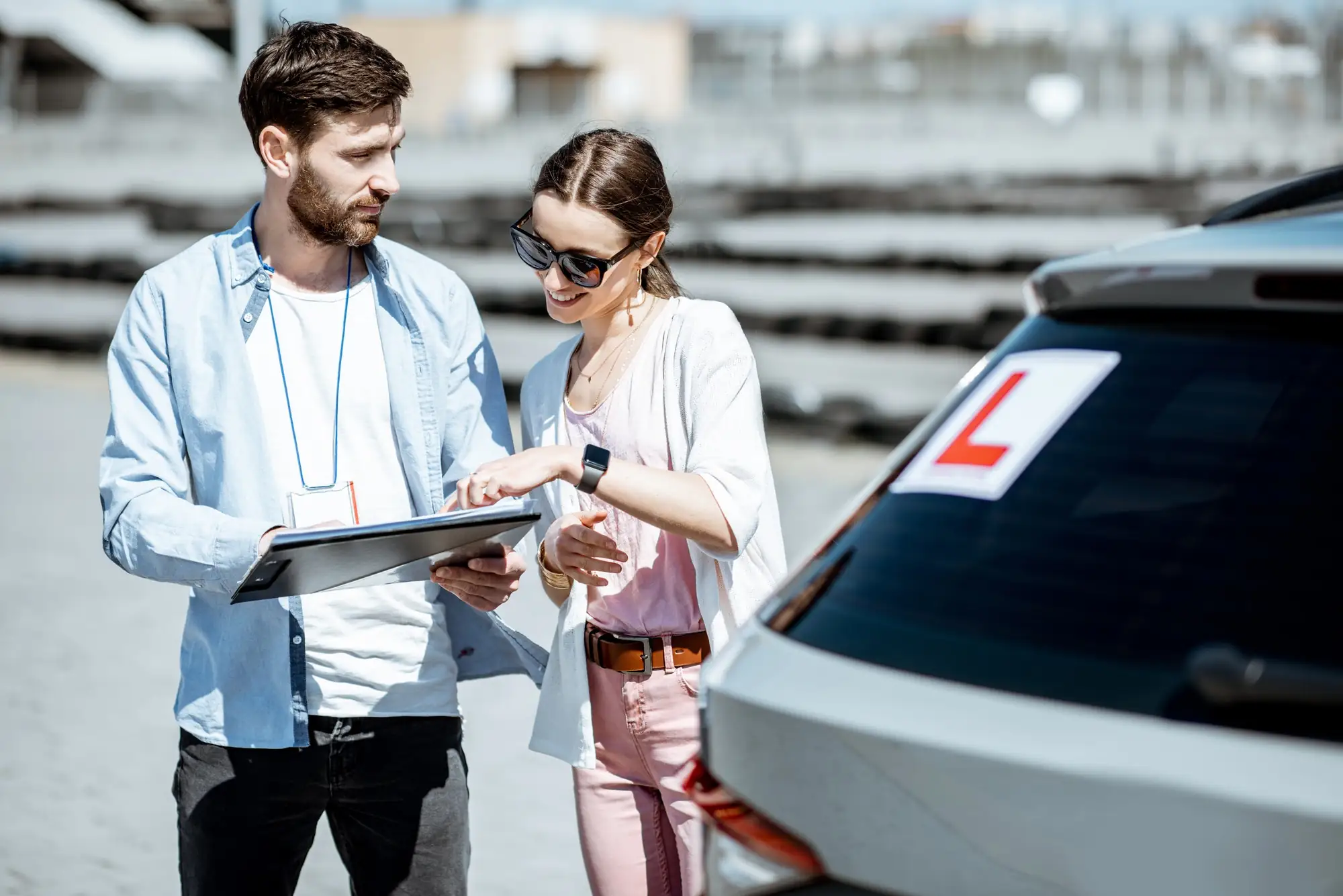Driving instructor showing a road layout diagram on a clipboard to a student during a road test preparation session at Canadian Way Driver Training